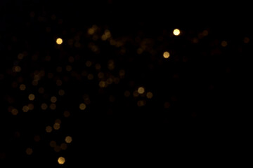 Golden blurred bokeh lights on black background. Glitter sparkle stars for celebrate. Overlay for...