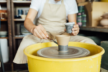 Hands of a potter. Potter making ceramic pot on the pottery wheel