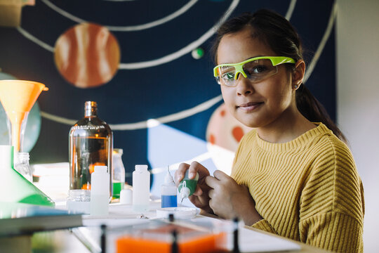 Portrait of female student doing science project at home