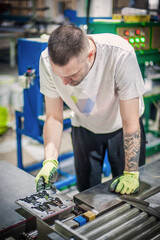 Technician making fridge magnet with soft PVC rubber in mold