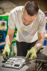 Technician making fridge magnet with soft PVC rubber in mold