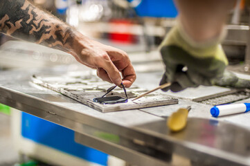 Technician making fridge magnet with soft PVC rubber in mold