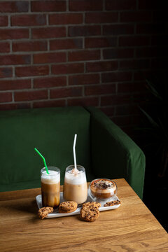 Coffee Iced Frappe Latte On Table Against Green Couch And Brick Wall