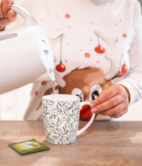 Young woman's hands with a cup of herbal tea, in time of cold and wellbeing