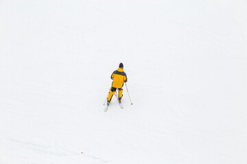 snowboarder is jumping with snowboard from snowhill. Skier skiing downhill in high mountains....