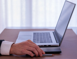 Executive hand in office with computer and mobile on table