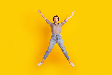 Fototapeta na wymiar Full size photo of young excited cheerful woman have fun jump wear casual outfit isolated over yellow color background