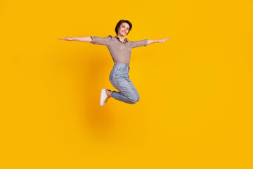 Fototapeta na wymiar Full size profile side photo of young pretty woman jump up fly hands plane isolated over yellow color background