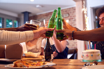 Multi-Cultural Group Of Friends Celebrating Birthday With Party And Cake At Home Together