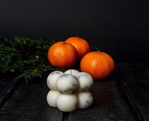 Fototapeta na wymiar candle and tangerines on dark blurred background copy space