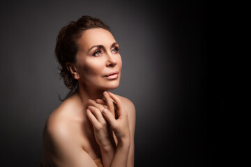 Fototapeta premium portrait of a sensual fifty year old woman on grey studio background