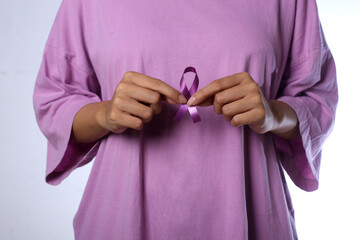 Woman holding purple violet ribbon, a world cancer day concept.