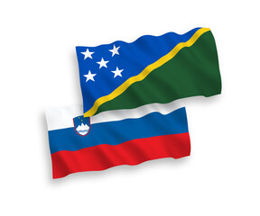 National vector fabric wave flags of Slovenia and Solomon Islands isolated on white background. 1 to 2 proportion.