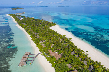 Perfect aerial scenic landscape, luxury tropical resort hotel with water villas and beautiful beach scenery. Amazing bird eyes view in Maldives, landscape seascape aerial view over a Maldives island