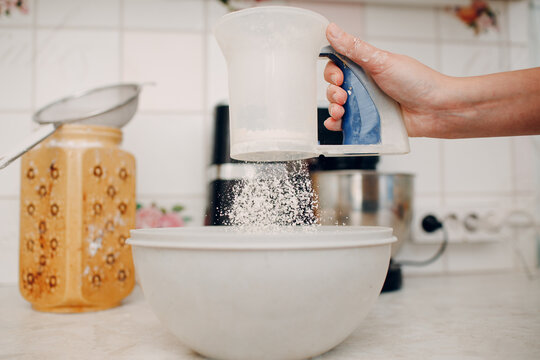 Pastry chef sift pours flour makes cake. Cooking and preparing dessert.