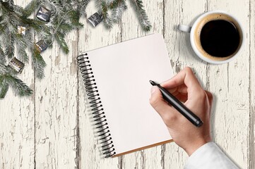 2021 New Year's resolutions with Christmas decorations. Hand writes in the notebook