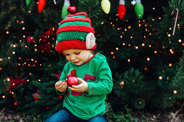 Christmas in july. children elf ears. Child waiting for Christmas in wood in july. portrait of little girl decorating christmas tree. winter holidays and people concept. Happy Holidays.