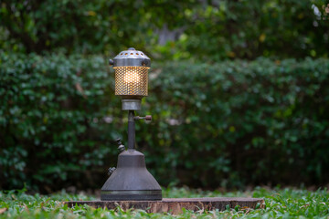 antique oil lamp On the grass in the forest in the evening camping atmosphere.Travel Outdoor Concept image.soft focus.