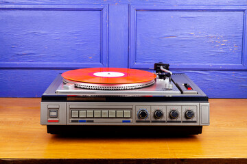 Vintage turntable vinyl record player with red vinyl
