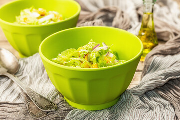 Tasty vegan salad from Chinese cabbage, sweet corn, purple onion, and dressing