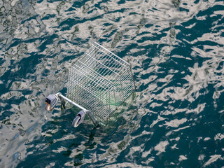 Top view of a dumped shopping trolley cart in the water