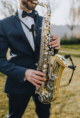Stylish man, musician, professional saxophonist in suit plays the saxophone.