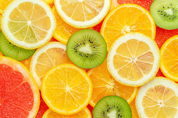 Fototapeta na wymiar Colorful summer citrus fruits slices background. Top view
