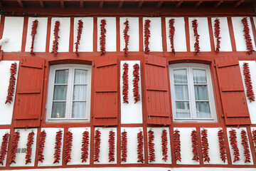 espelette pimientos rojos colgados el la fachada de una casa con ventanas rojas francia país vasco...