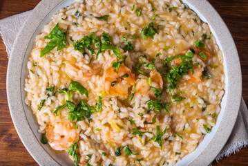 Risotto with shrimps in a plate, top view, close-up - healthy Italian cuisine