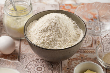 Baking ingredients for dough - white flour, eggs, milk, yeast, sugar, salt - on blue surface