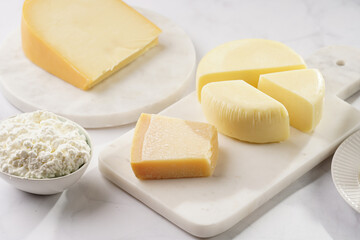 Various cheese types on marble and porcelain plates - ingredients for traditional georgian open pie khachapuri