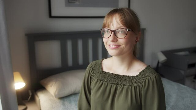 Happy Woman With Positive Thoughts Smiling While Sitting on Bed on Bright Morning, Close Up