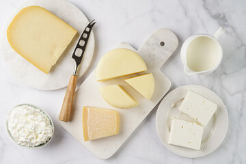 Various cheese types on marble and porcelain plates - ingredients for traditional georgian open pie khachapuri
