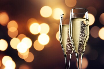 Beautiful glasses with champagne clink greet congratulate with New Year. Celebration concept.