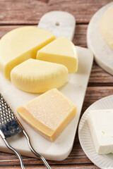 Various cheese types on marble and porcelain plates and fresh dough - ingredients for traditional georgian open pie khachapuri