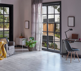 Modern rom with working table and armchair style, parquet floor, frame lamp decor, curtain, garden view house interior.