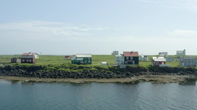 Traditional Cottages On The Coastal Town Of Flatey Island, Breidafjordur Bay In Iceland. Aerial Tracking