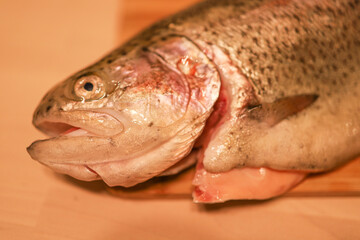 fresh river salmon lies on a wooden cutting board in the apartment. Cooking, butchering fish, omega...