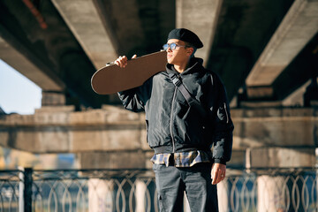 Skater male with skateboard posing on street urban background