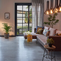 Room interior sofa and working table style, metal lamp, vase of plant, garden view, middle coffee table, blanket, parquet floor, home design.