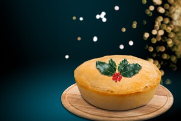 Fototapeta na wymiar Christmas pudding, fruit cake. Traditional festive dessert. Dark background with lights garland.