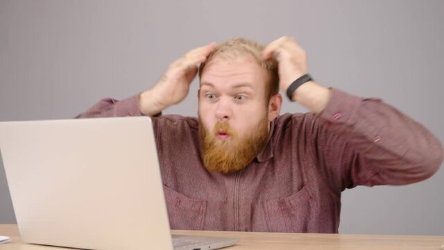 Happy bearded caucasian business man working on laptop from home office. Male executive using computer remote studying, browsing web, having virtual meeting. 