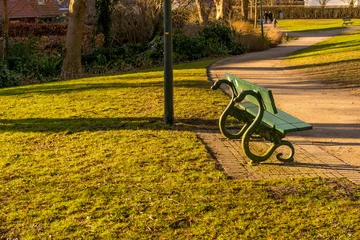 Foto auf Alu-Dibond Path going through a park with green lawns and benches, Bruges, Belgium © Ramana Suryanarayana/Wirestock