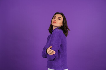 Obraz premium Young woman in a purple soft cozy sweater on the background of cute smiling cheerfully, in high spirits, confident smile, bright makeup with lipstick