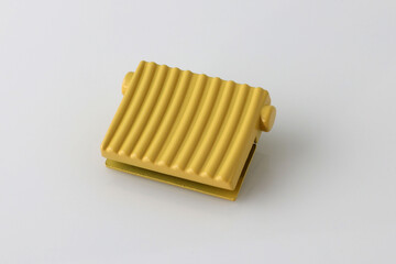 Metallic Square yellow decoration for a bag on a white background. Decor element for a bag or a woman's backpack close-up. Metal bag accessories.