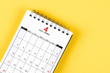 April 2022 desk calendar on yellow background.