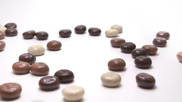 Dutch traditional sweets: chocolate covered pepernoten. White background. Slow motion shot