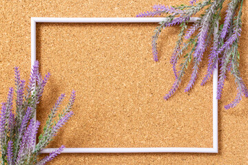 on a cork background, an empty frame with branches of lavender. romantic mood