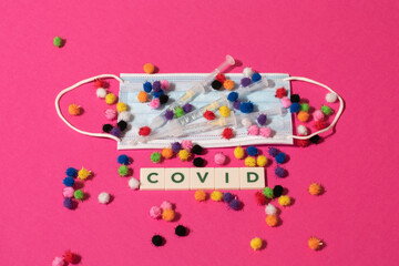 Vaduz, Liechtenstein, December 17, 2021 Virus variations on a medical face mask and syringes