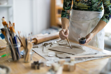Close-up of craftswoman working on her pottery in workshop
